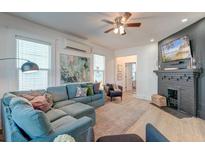 Bright living room featuring a comfortable sectional sofa, fireplace, and large TV at 33 Cypress St, Charleston, SC 29403