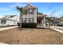 Gray house with red door, palm tree, and manicured lawn at 4140 Home Town Ln, Ravenel, SC 29470