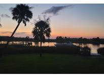 Stunning sunset over calm water, palm trees, and boats at 4960 Lambs Rd, North Charleston, SC 29418
