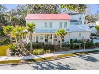 Two-story white house with red metal roof, landscaping, and palm trees at 1086 Cinder St, Mount Pleasant, SC 29464
