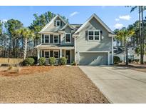 Two-story house with gray siding, a large driveway, and landscaping at 123 Beam St, Huger, SC 29450