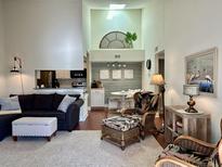 Bright living room with sectional sofa, ottoman, and wicker chairs, overlooking kitchen and dining area at 1481 Center Street Ext # 1808, Mount Pleasant, SC 29464