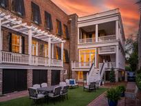 Charming backyard with brick patio, artificial turf, and seating area at 38 Hasell St, Charleston, SC 29401