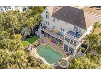 Aerial view of a luxury home with pool and lush landscaping, located near the water at 65 Ocean Point Dr, Isle of Palms, SC 29451
