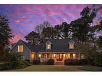 Gray two-story home with a covered porch and brick steps at dusk at 935 Paul Revere Dr, Charleston, SC 29412