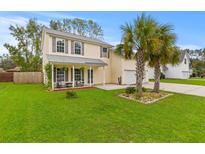 Two-story house with front porch, palm trees, and a well-manicured lawn at 106 Elon Dr, Ladson, SC 29456