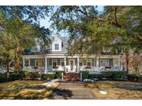 Two story home with wrap around porch and mature landscaping at 166 Beresford Creek St, Charleston, SC 29492