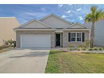 Brick house with a white garage door and landscaping at 219 Greenwich Dr, Summerville, SC 29486