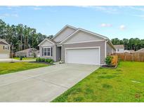 Single-story home with attached garage and landscaped lawn at 221 Rubles Ln, Moncks Corner, SC 29461