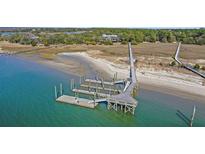 Aerial view of waterfront property with private dock and expansive marsh views at 153 Dewees Inlet Dr, Dewees Island, SC 29451
