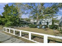 Charming home with a spacious front yard, large tree, and white fence at 186 Sans Souci St, Charleston, SC 29403
