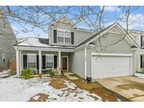Two-story house with light green siding, white garage door, and a porch at 2005 Isabela Ct, Summerville, SC 29483