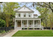 Two story white house with wrap around porch and landscaped yard at 267 Delahow St, Charleston, SC 29492