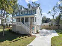 Two-story home with gray siding, white trim, and a detached garage at 3893 James Bay Rd, Johns Island, SC 29455