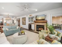 Bright living room features a fireplace, comfy seating, and large TV at 407 Yacht Harbor Ct, Isle of Palms, SC 29451