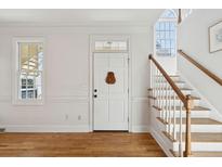 Bright entryway with hardwood floors, staircase, and white door at 5 Wraggborough Ln, Charleston, SC 29403
