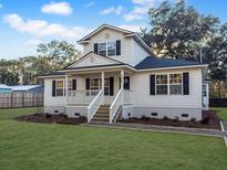Two-story house featuring a white exterior, black shutters, and a landscaped lawn at 538 Harris Hill Rd, Johns Island, SC 29455