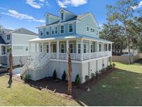 Two-story house with light blue siding, white trim, and a wrap-around porch at 6522 Beagle Club Rd, Meggett, SC 29449