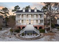 Brick two-story home with a large front porch and landscaping at 7003 Old Landing Dr, Hanahan, SC 29410