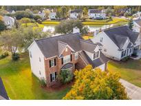 Aerial view of two-story house with brick accents, situated in a neighborhood near a pond at 7152 Windmill Creek Rd, Charleston, SC 29414