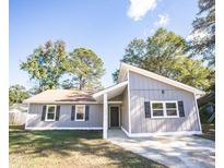 Newly renovated home with gray siding, landscaping, and a spacious driveway at 780 Corral Dr, Charleston, SC 29414