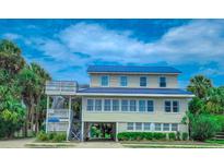 Two-story beach home with a metal roof and spacious deck at 209 Palmetto Blvd, Edisto Beach, SC 29438