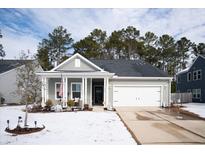 Gray house with white garage door and porch, nestled on a snow-covered lawn at 221 Lucca Dr, Summerville, SC 29486