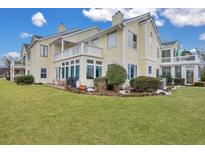Back exterior of charming yellow home with landscaping and spacious yard at 2345 Tall Sail Dr # C, Charleston, SC 29414