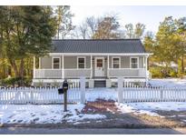 Charming gray house with white picket fence and snowy yard at 301 Beaufort St, Summerville, SC 29483