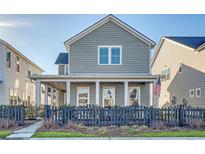 Gray two-story home with black picket fence, American flag, and landscaping at 1332 Clay Field Trl, Summerville, SC 29485