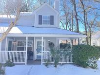 Charming gray house with a white porch, covered in snow, and surrounded by trees at 1378 Cassidy Ct # B, Mount Pleasant, SC 29464