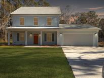 Two-story light blue house with a double garage and a manicured lawn at 1421 Brownswood Rd, Johns Island, SC 29455