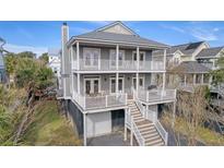 Two-story home with gray siding, multiple decks, and a detached garage at 209 Charleston Blvd, Isle of Palms, SC 29451