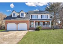 Brick home with two-car garage, front porch, and landscaped lawn at 2147 Hunter Creek Dr, Charleston, SC 29414