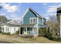 Charming teal two-story home with a yellow door and covered porch at 5169 Celtic Dr, North Charleston, SC 29405