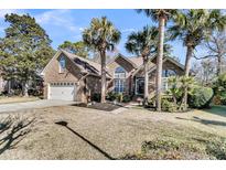 Brick house with palm trees, landscaped yard, and attached garage at 1449 Waterside Ct, Mount Pleasant, SC 29464