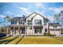 Two-story home with gray siding, large windows, and a three-car garage at 3917 Delinger Dr, Mount Pleasant, SC 29466