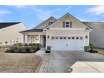 Tan house with white garage door and landscaping at 614 Beach Way, Summerville, SC 29486