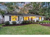 Charming white brick ranch home with landscaped yard and evening lighting at 7 Arcadian Park, Charleston, SC 29407