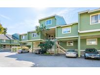 Green multi-unit building with parking and tropical landscaping at 7000 Palmetto Dr # 3F, Isle of Palms, SC 29451