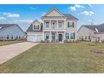 Two-story house with a neutral color scheme, double garage, and a well-manicured lawn at 7003 Pumpkinseed Dr, Johns Island, SC 29455