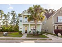 Charming two-story light green house with palm tree and walkway at 7468 Northgate Dr, Hanahan, SC 29410