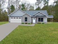Gray brick home with white garage door and landscaped lawn at 1034 Weeks Lane, Round O, SC 29474