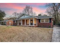 Brick ranch house with covered porch and landscaped yard at 1111 Barrett Rd, Charleston, SC 29407