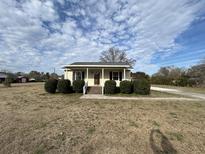 Ranch home with front porch and landscaped yard at 206 Dora Dr, Saint George, SC 29477