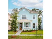 Charming light blue two-story house with a front porch and well-manicured lawn at 2253 Blue Bayou Blvd, Johns Island, SC 29455