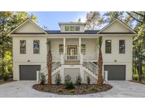 Two-story house with white siding, gray garage doors, and a front porch at 5105 St George Ln, Hollywood, SC 29449