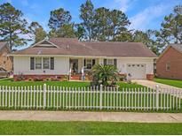 One-story home with white siding, a white picket fence, and a spacious lawn at 917 Aleppo Dr, Ladson, SC 29456