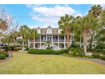 Two-story house with a large front yard, palm trees, and a basketball hoop at 15 31St Ave, Isle of Palms, SC 29451