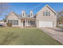 Beige two-story house with a large front yard, two-car garage, and black shutters at 157 Spring Meadows Dr, Summerville, SC 29485